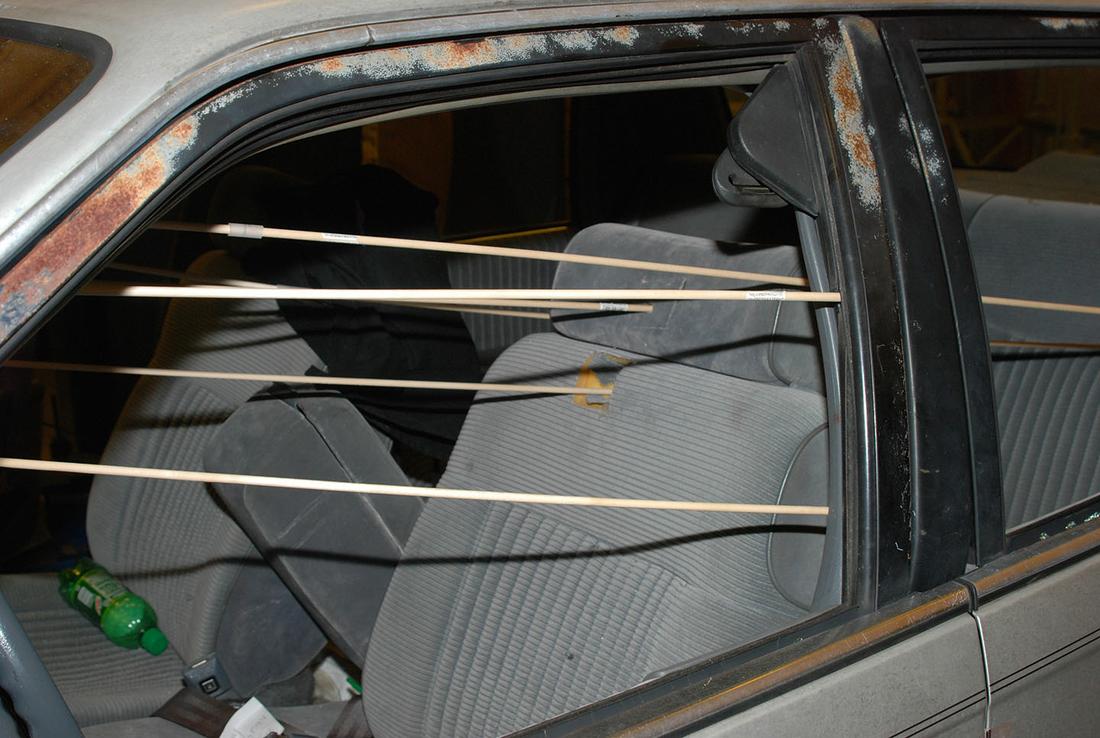 Investigators mark the direction of the bullets that struck the driver side of Caroline Small's car. (Police photo)